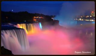 Niagra Falls, at night, with the falls lit up by brightly colored lights