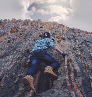 human free-climbing up a rock face