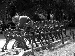 person_bent_over_park_benches