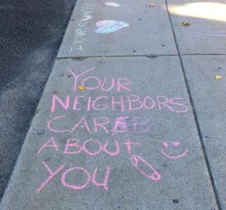 An example of neighborhood love notes in sidewalk chalk, "your neighbors care about you"