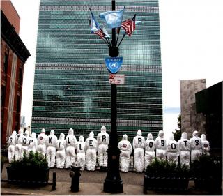 Campaigners stand in front of the UN Headquarters wearing white jumpsuits emblazoned with letters that spell out "Stop Killer Robots"