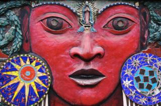 A close up of a richly colored bas-relief mural depicting a beautiful and powerful Mexican goddess, Tonantzin