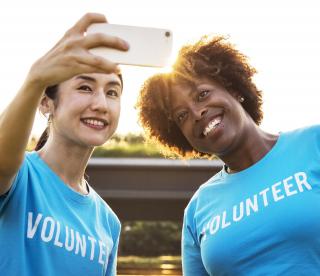 Two people in "volunteer" shirts taking a selfie