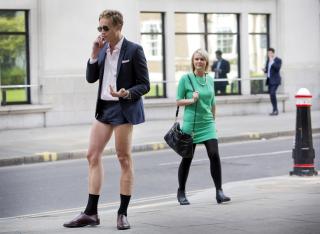 A model seen here walking through London in short shorts in London, England, with a passerby giving him a quizzical look..