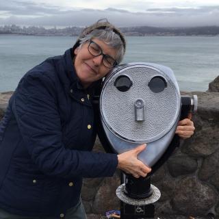 Julie Fanselow, in jest, hugs an outdoor binocular post.