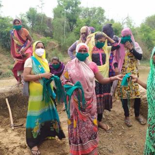 Women in India distributing face coverings in wooded outdoor area