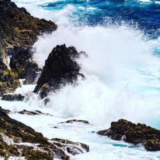 ocean waves hitting rocks and creating spray