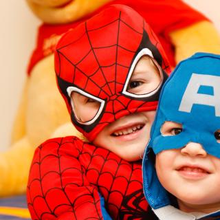 Two small children, in superhero costumes: one is Spiderman