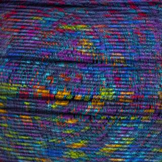 A close-up photo of woven fabric in rich tones of blue, with yellow, red, and purple threads. 