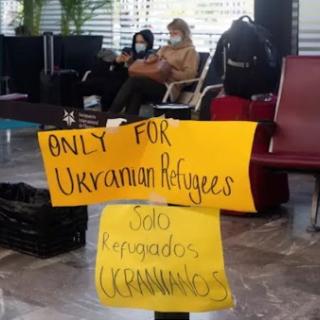 A sign in an airport reading "Only for Ukrainian Refugees / Solo Refugiados Ucranianos"
