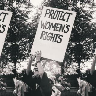 Three identical black-and-white images side-by-side of person at protest holding sign reading "Protect Women's Rights"