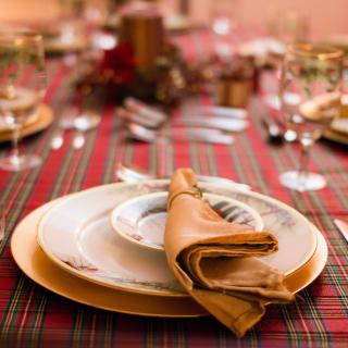 image of a table with a formal placesetting, two plates, napkin, silverware, several stem glasses
