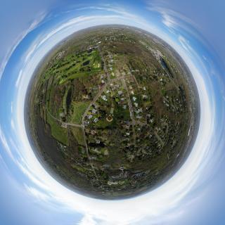 A 360-degree panorama photo, taken above an outdoor field, edited into a ‘Little Planet’ style photo.