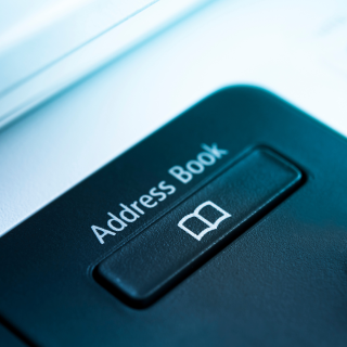 A close-up of a hard-case address book with a button that has a book icon on it. 