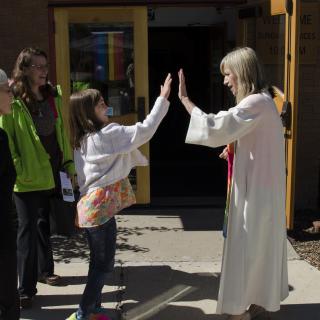 Rev. Katie Kandarian-Morris high fives a youth