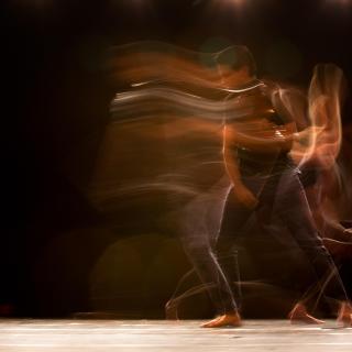 A time-lapse photo showing graceful, dance-like movements of a person against a black background