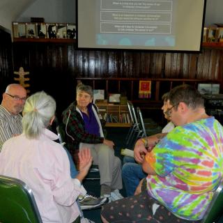 One discussion group at work in sanctuary with questions on display in background