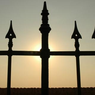 Wrought Iron fence with sunset