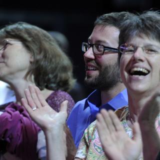 People clap and sing at a worship service at General Assembly