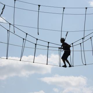 silhouette of a person on a ropes course