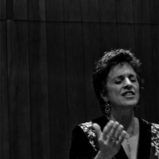 A photo of Linda Hirschhorn, eyes closed and hands raised in prayer, with the caption "photo J. Lubitz"
