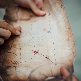 Two set of hands holding a handmade map