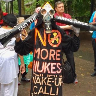 Demonstrator wearing an anti-radiation mask and an outfit that says "No More Nukes"