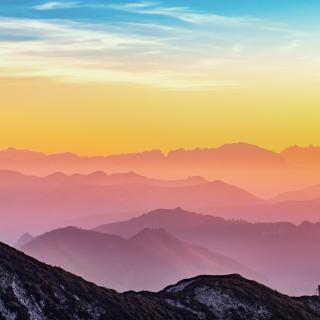 A horizon of mountain ridges, colorized in pastel rainbow tones.