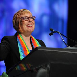 Rev. Dawn Cooley stands at the pulpit at UUA GA 2-16