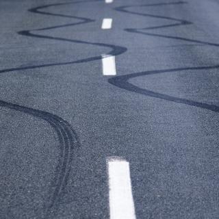Winding skid marks of a vehicle on a street. 