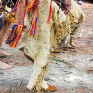 The feet and legs of several members of the Narragansett tribe, in traditional dress, at their 2012 pow-wow.