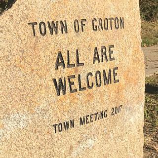 A stone engraved with "Town of Groton ALL ARE WELCOME Town Meeting 2017"
