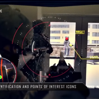 Screenshot from U.S. army video showing soliders carrying guns, pointed at a person labeled "target" with a GPS tracker in the bottom corner