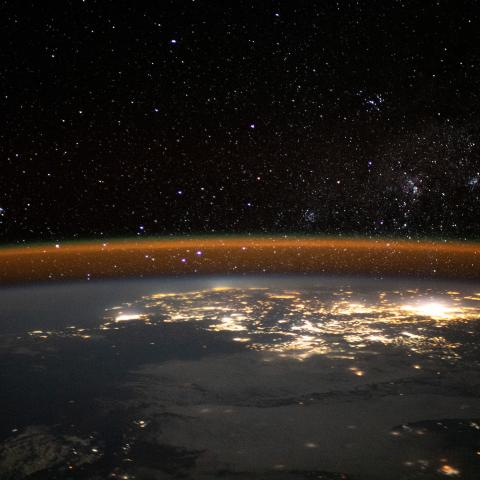 A starry night sky and and an atmospheric glow blanket the well-lit southeastern African coast as the International Space Station orbited 263 miles above.