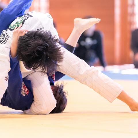 A close up of two competitors, mid-match, at the Brazilian Jiu-Jitsu Shinbun Championship (2017).